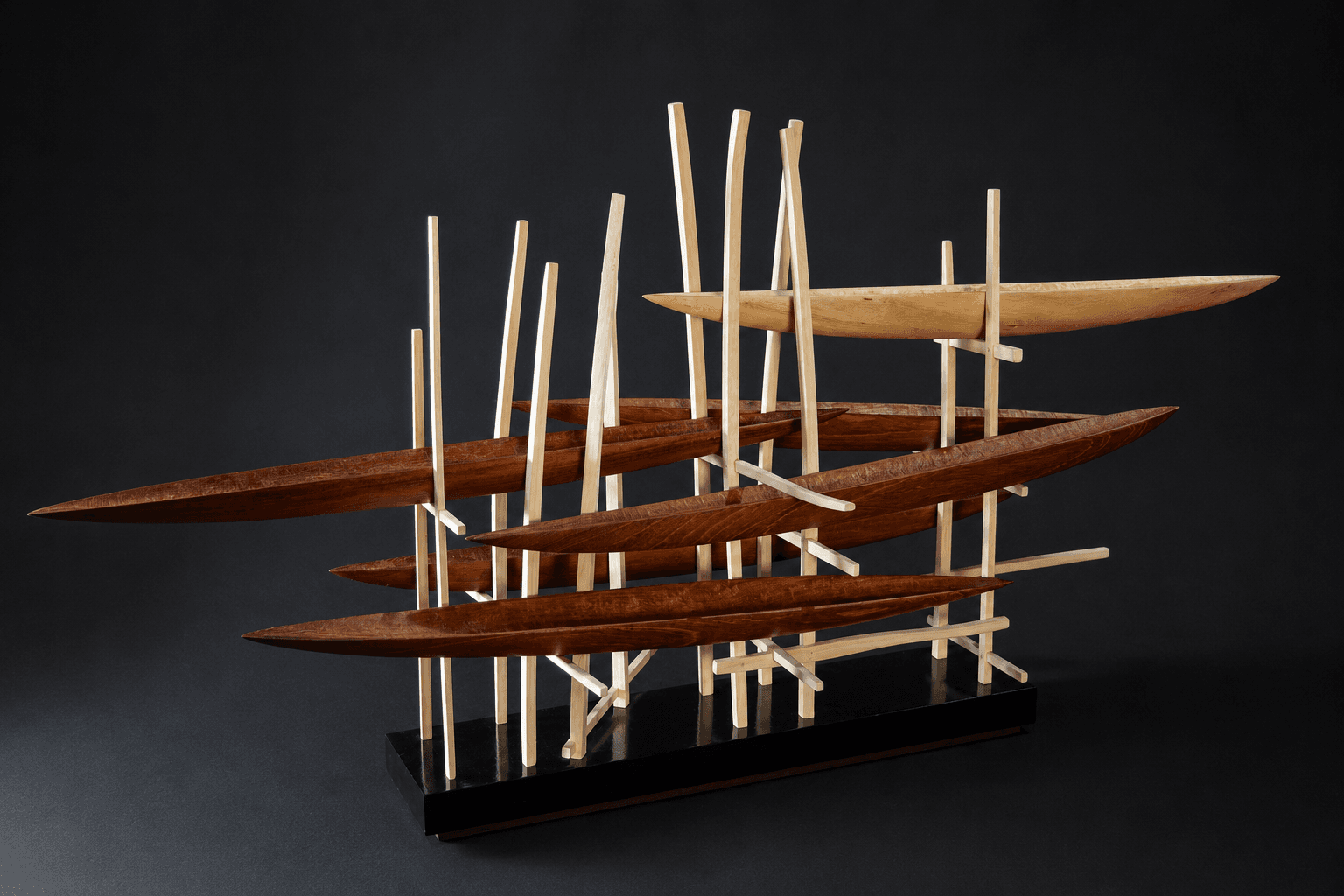 Cardumen, escultura de José Koropecki en madera sobre base policromada negra, perteneciente a la serie Astilleros.