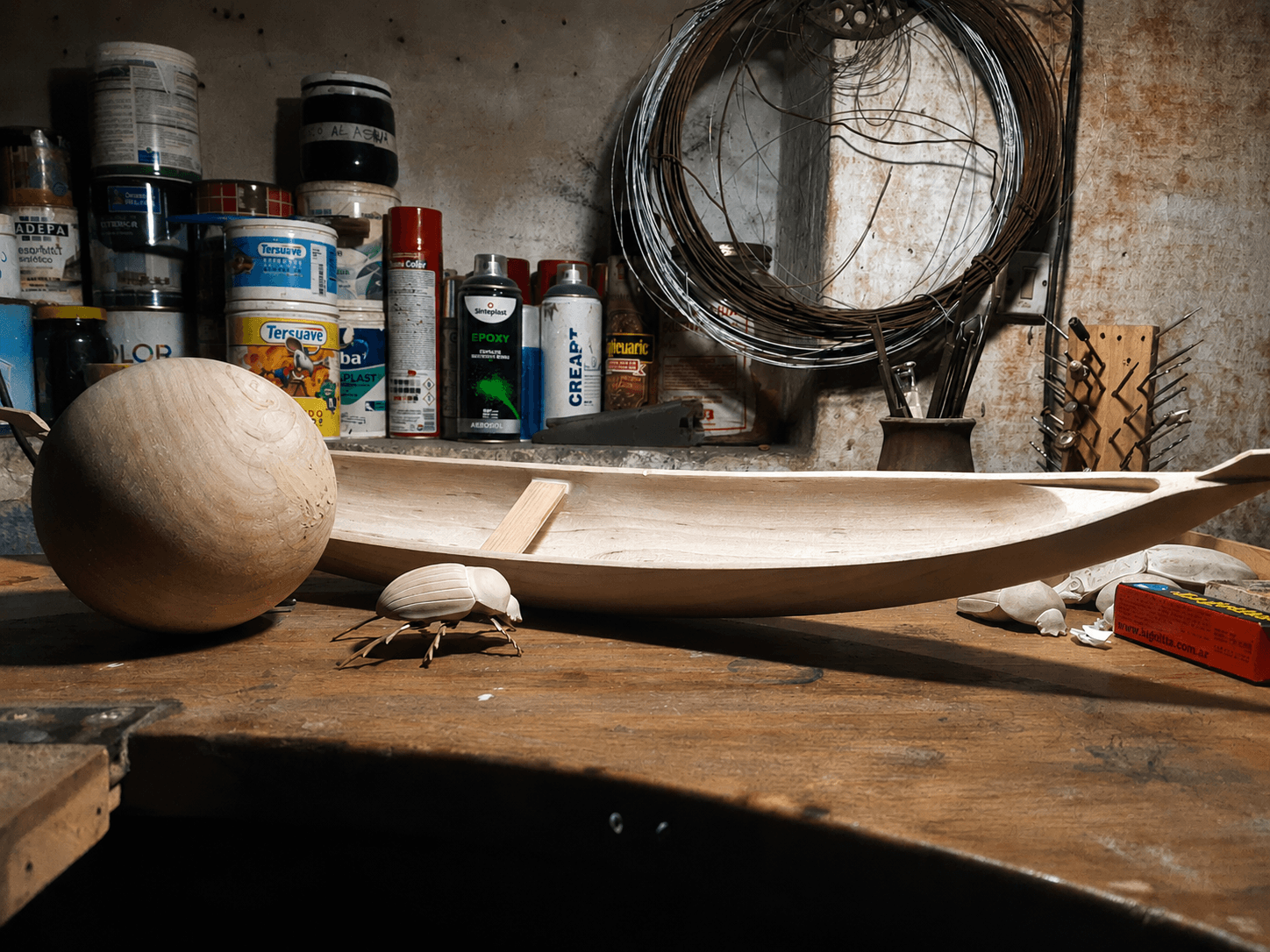 Mesa de taller de José Koropecki con materiales, herramientas y fragmentos de obra en proceso.